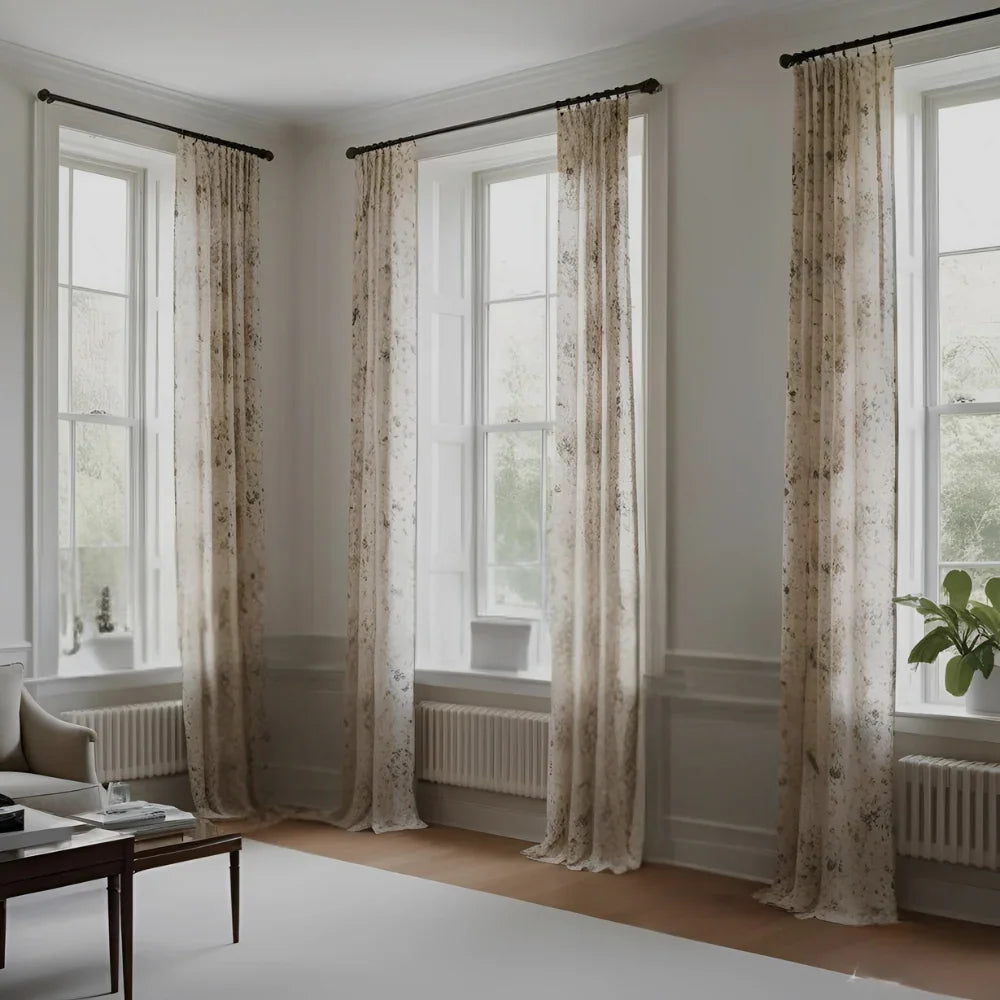 A cozy, modern living room featuring a large window dressed with layered curtains.