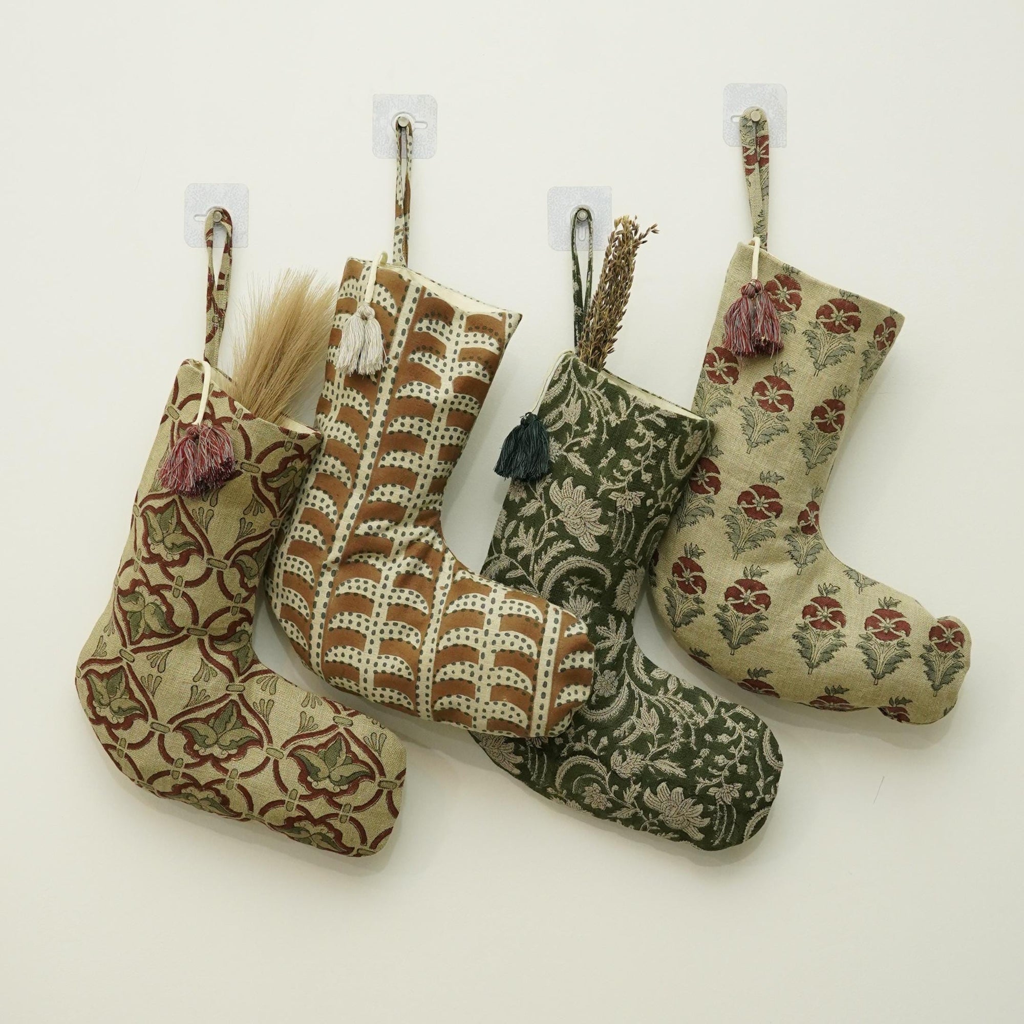 Four patterned Christmas stockings hanging on white background.