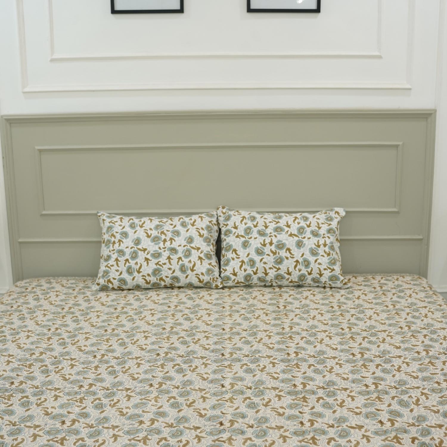 Let your bedroom bloom with handcrafted beauty. This hand block printed bedsheet on pure cotton, paired with pillow covers, captures floral artistry in soft tones. Each piece echoes heritage and the skill of artisans.