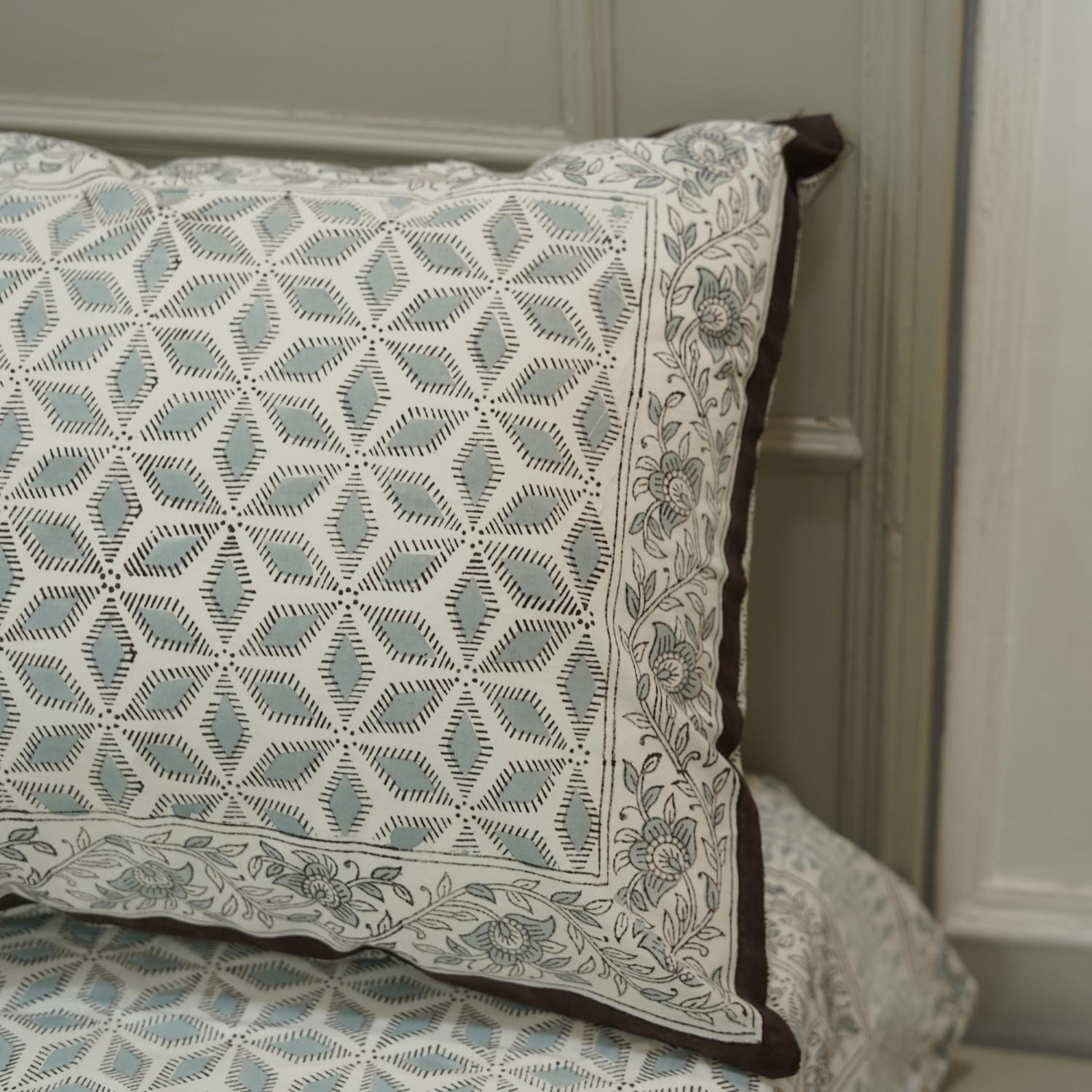 Decorative pillow with geometric pattern on a bed