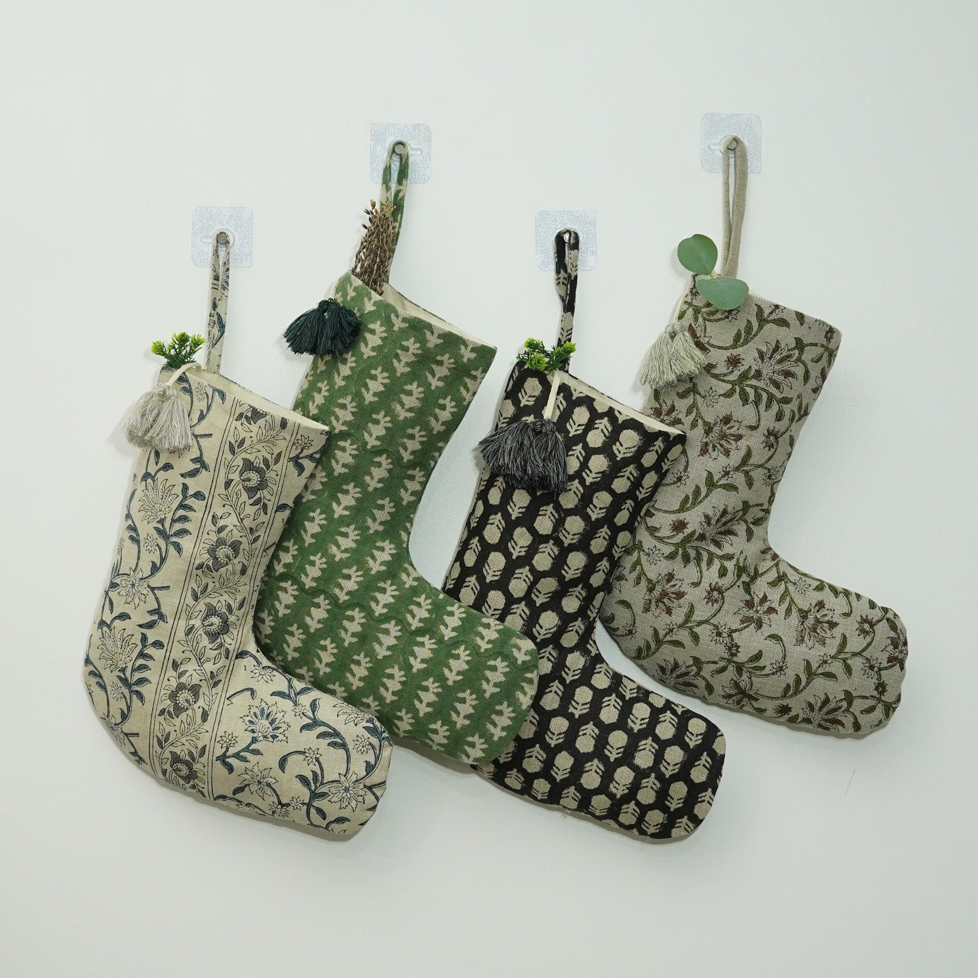 Four patterned Christmas stockings hanging on white background.