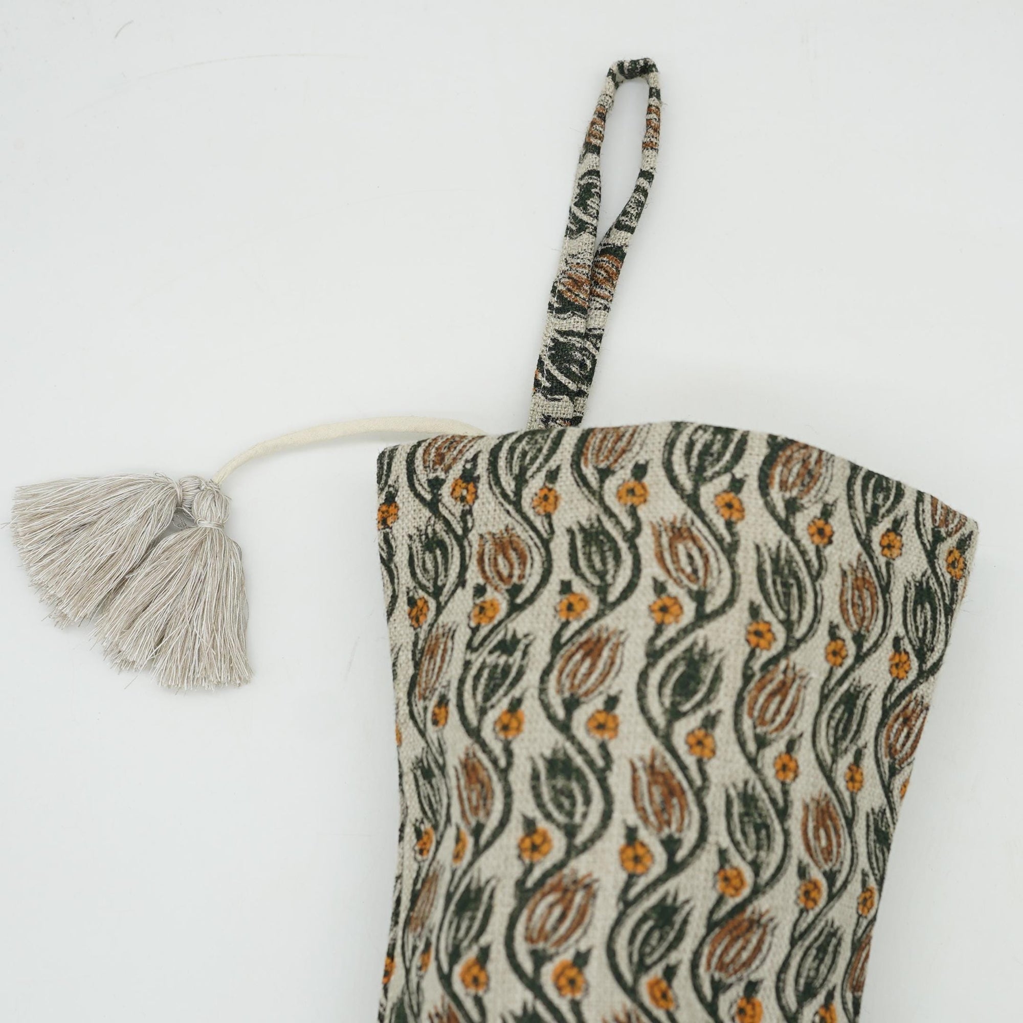 Patterned fabric bag with tassel on white background.