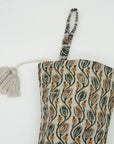 Patterned fabric bag with tassel on white background.
