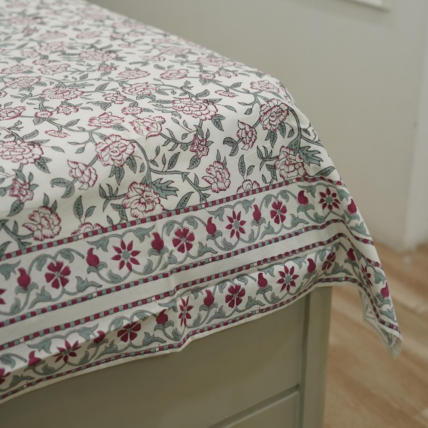 Floral patterned fabric draped over a piece of furniture with a neutral background