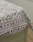 Floral patterned fabric draped over a piece of furniture with a neutral background