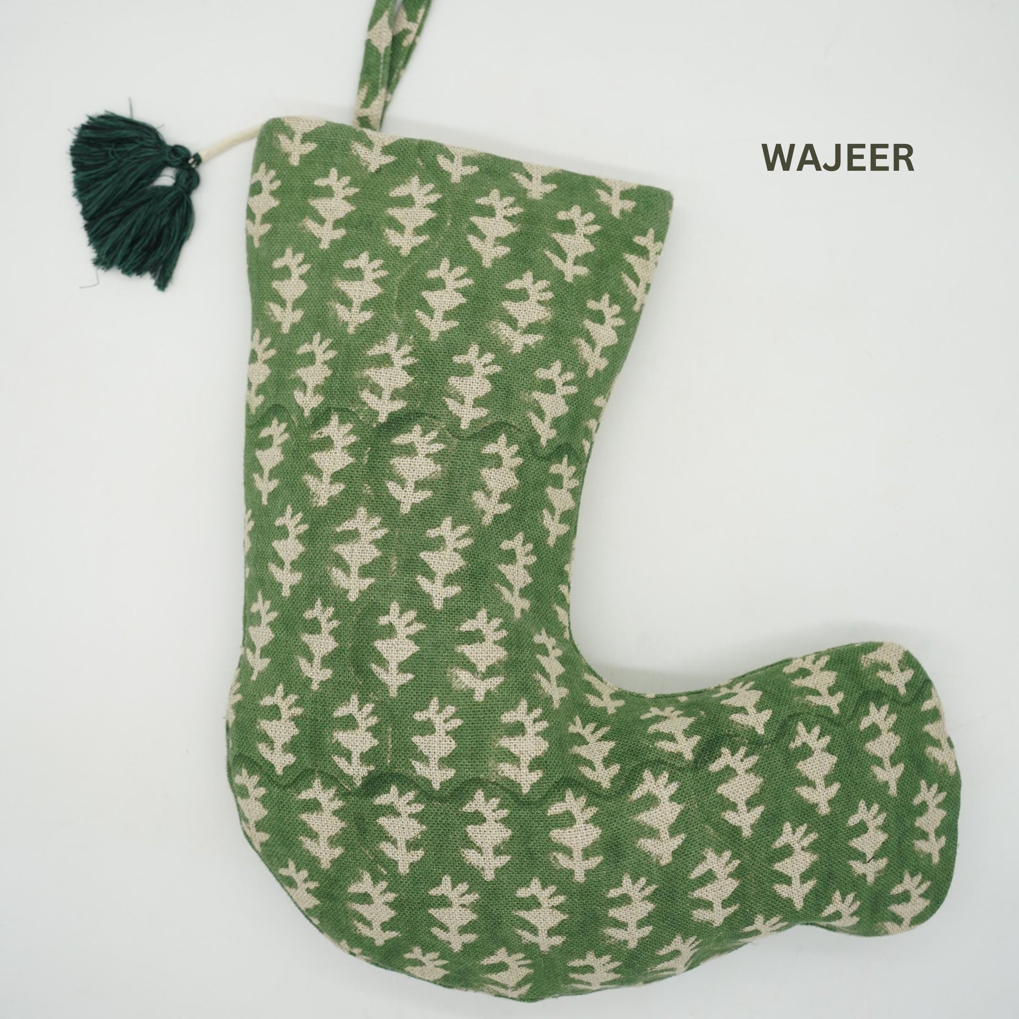 Green and beige patterned bag with tassel, branded 'WAJEER', on white background.