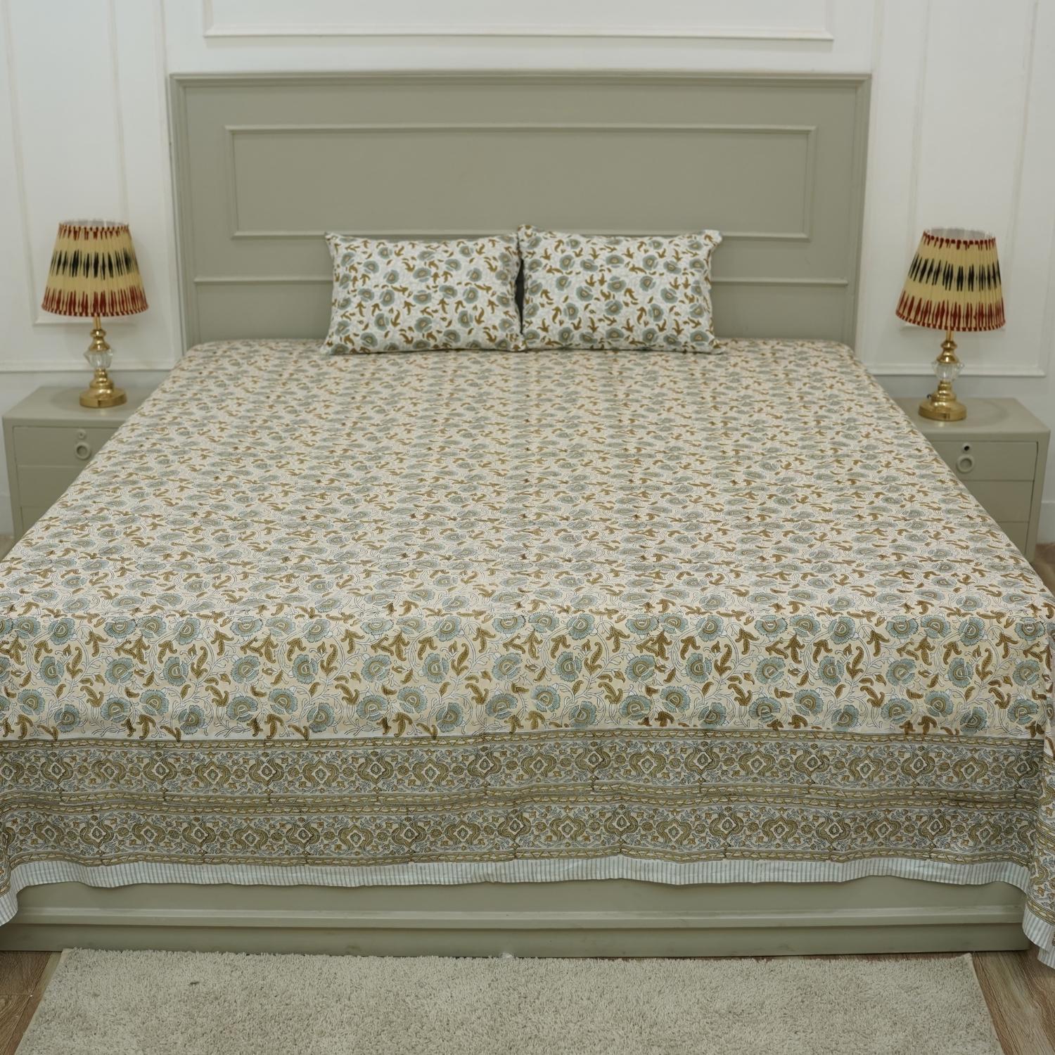 Elevate your space with bohemian elegance through this hand block printed cotton bedsheet set. Designed with intricate floral motifs and paired with pillow covers, this bedding brings handcrafted warmth and natural beauty into your room.
