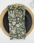 Green block print frill napkin on a warm dining table setting.