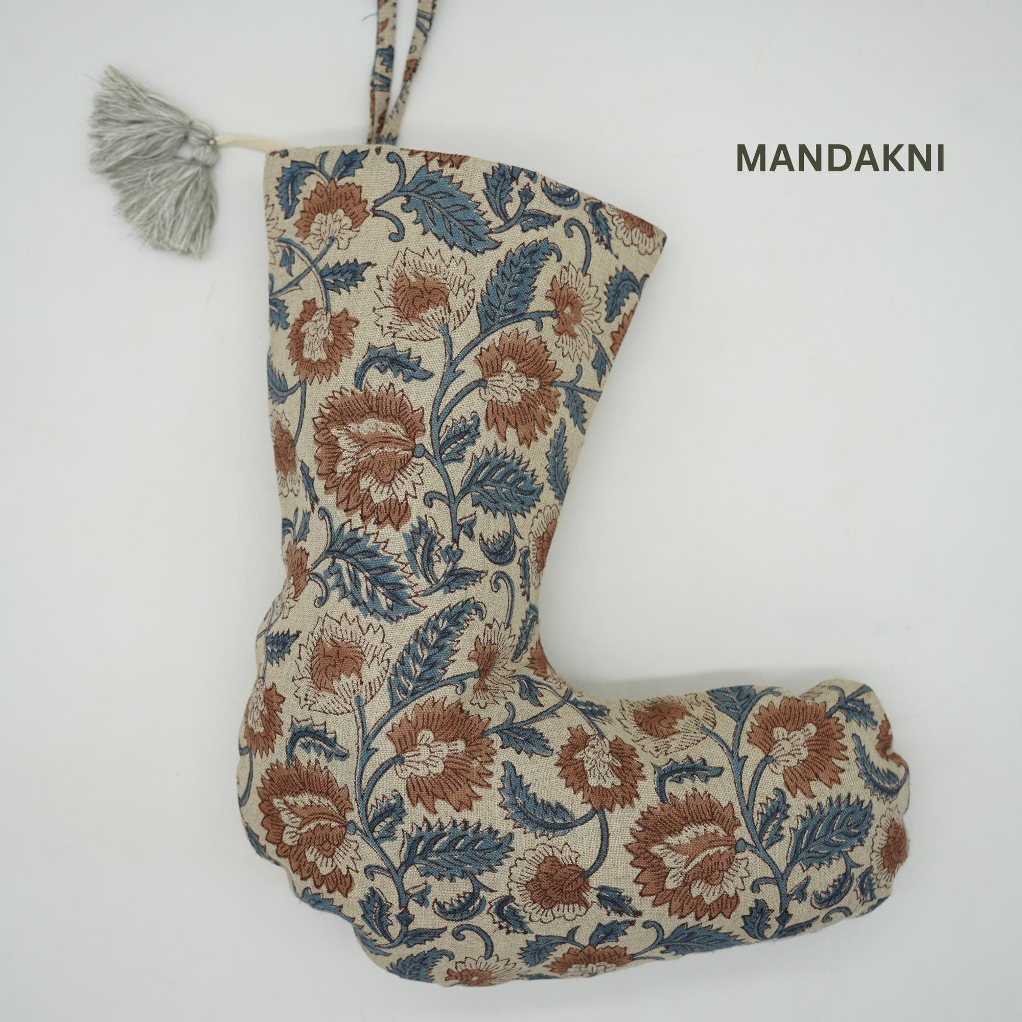 Decorative stocking with floral pattern, tassel, and 'Mandakini' branding.