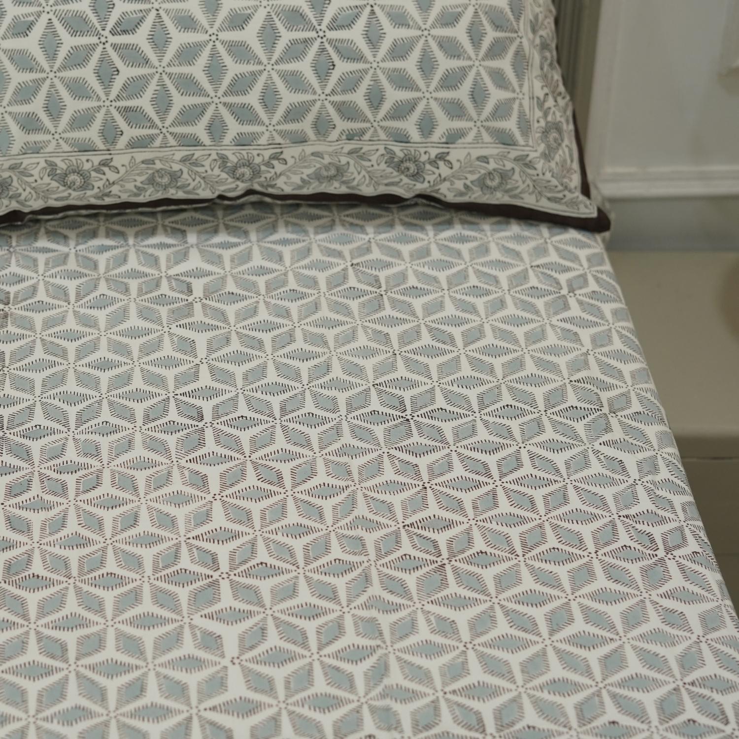 Bedspread with geometric pattern on a bed in a room setting