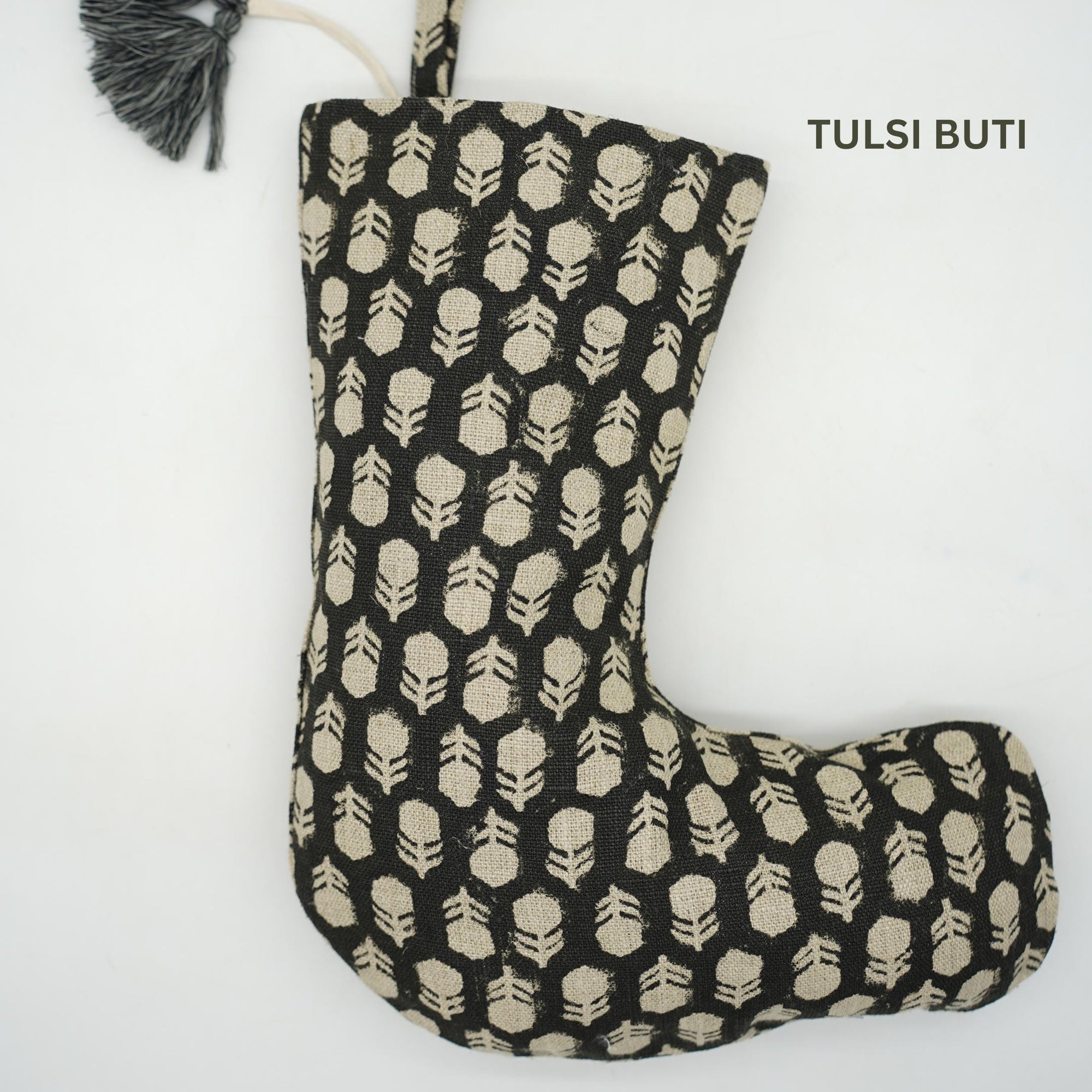 Black stocking with beige geometric pattern, branded 'Tulsi Buti', on white background.
