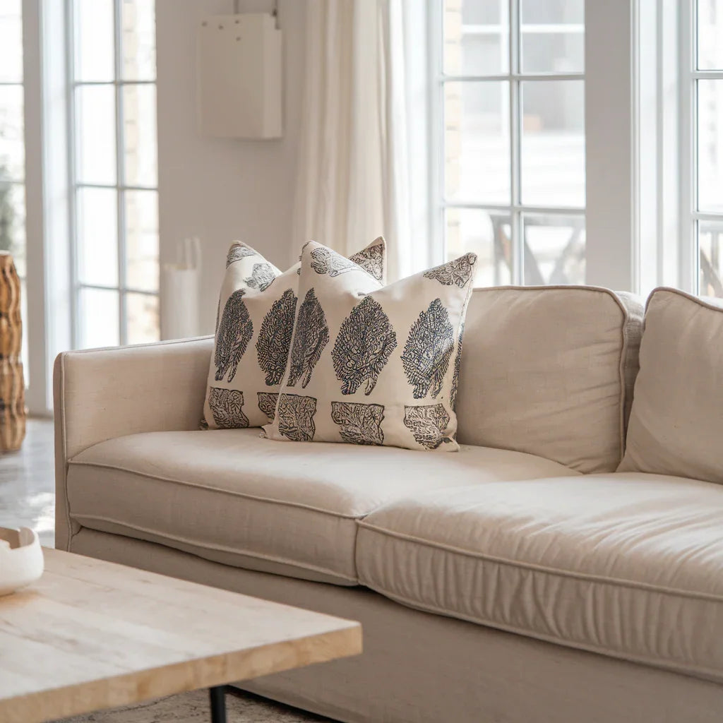 A photo of a cozy living room with a beige linen sofa. The sofa is adorned with Fabdivine's artistic block printed throw pillows.