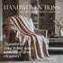 beautiful, intricately woven throw draped over a cozy armchair, with soft, warm colors that exude comfort and sophistication. The background features a tastefully designed living room that embodies the essence of modern American home decor. 
