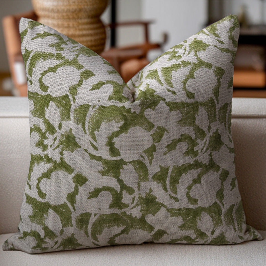 Floral patterned pillow on a sofa with a blurred background