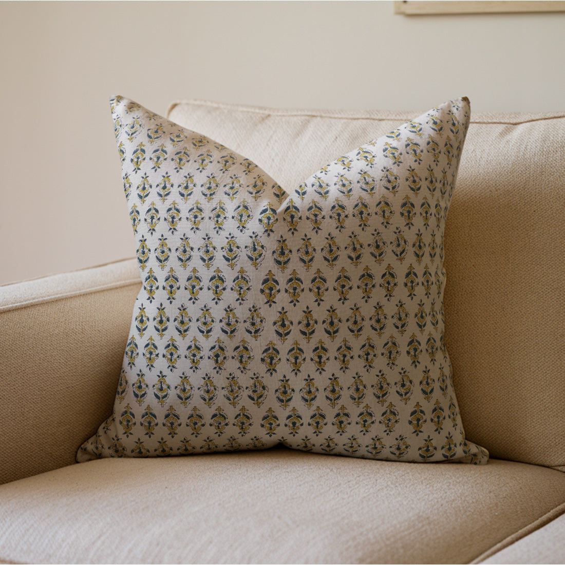 Decorative pillow with a floral pattern on a beige couch