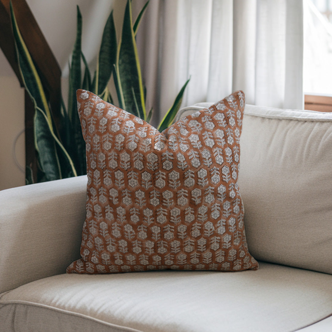 Decorative brown pillow with a floral pattern on a beige sofa