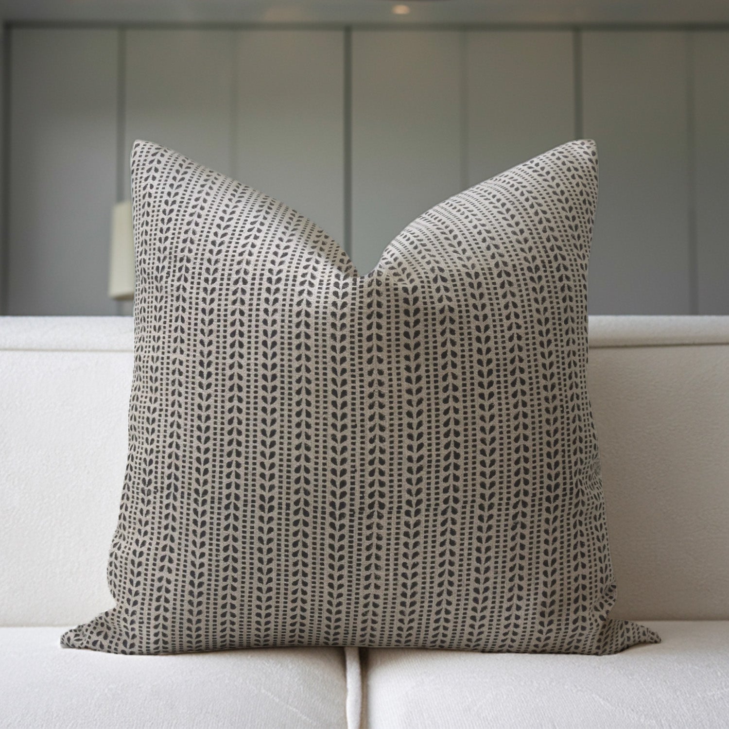 Textured pillow on a white sofa with a neutral background