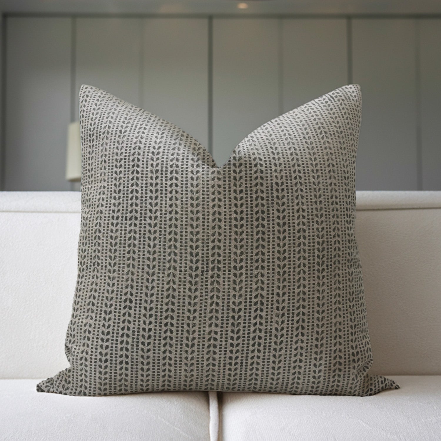 Textured pillow on a white sofa with a neutral background