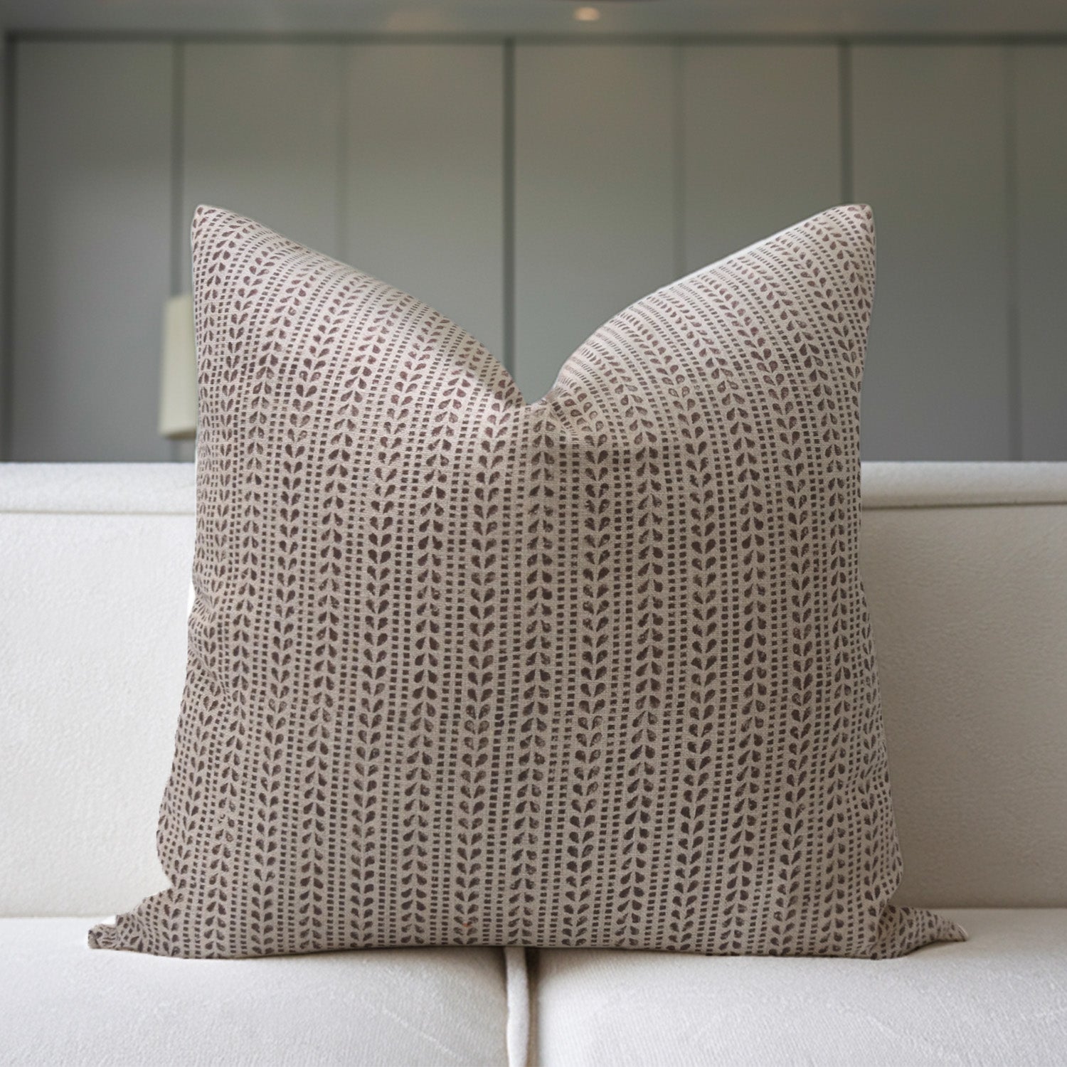 Textured pillow on a light-colored sofa with a neutral background