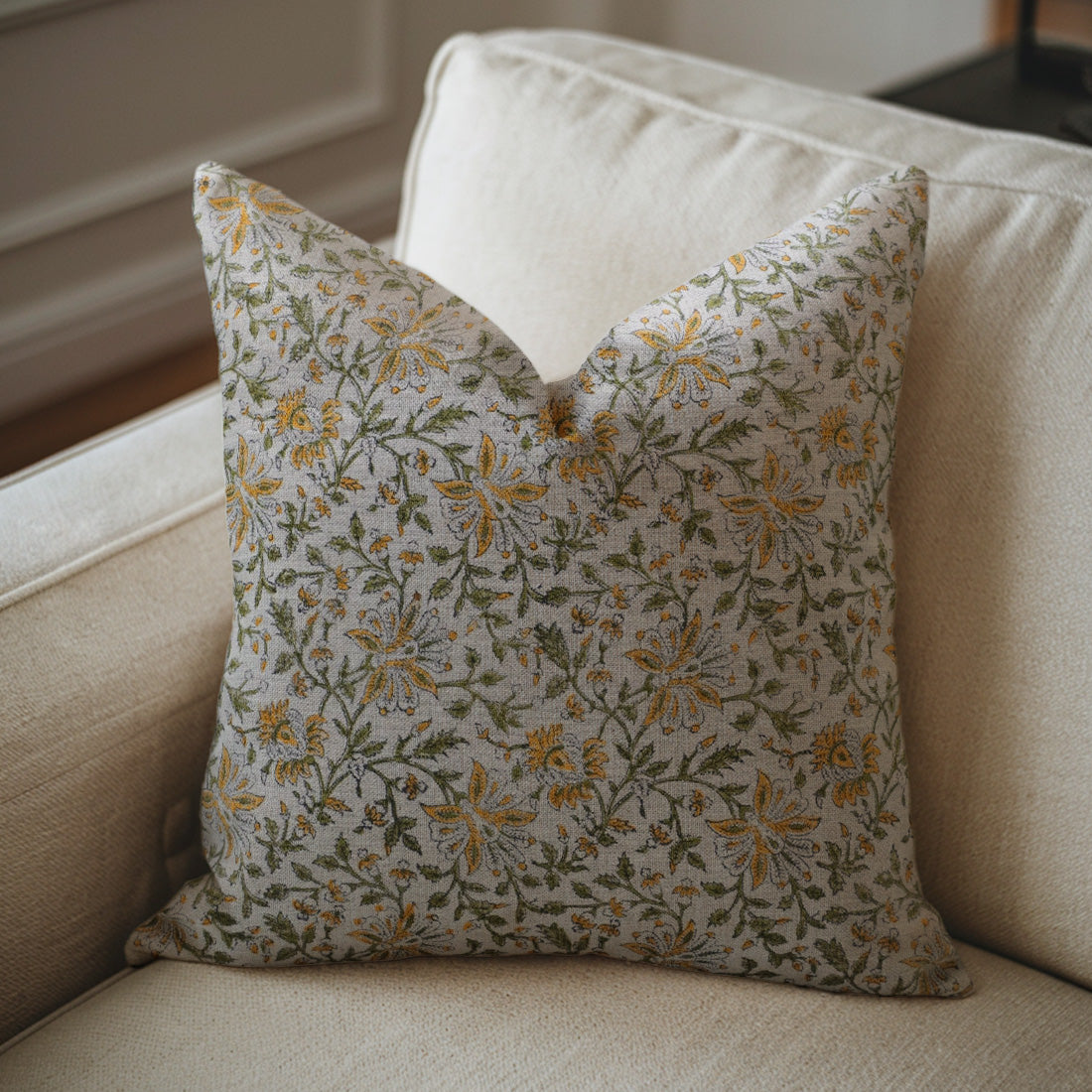 Floral-patterned pillow on a beige sofa