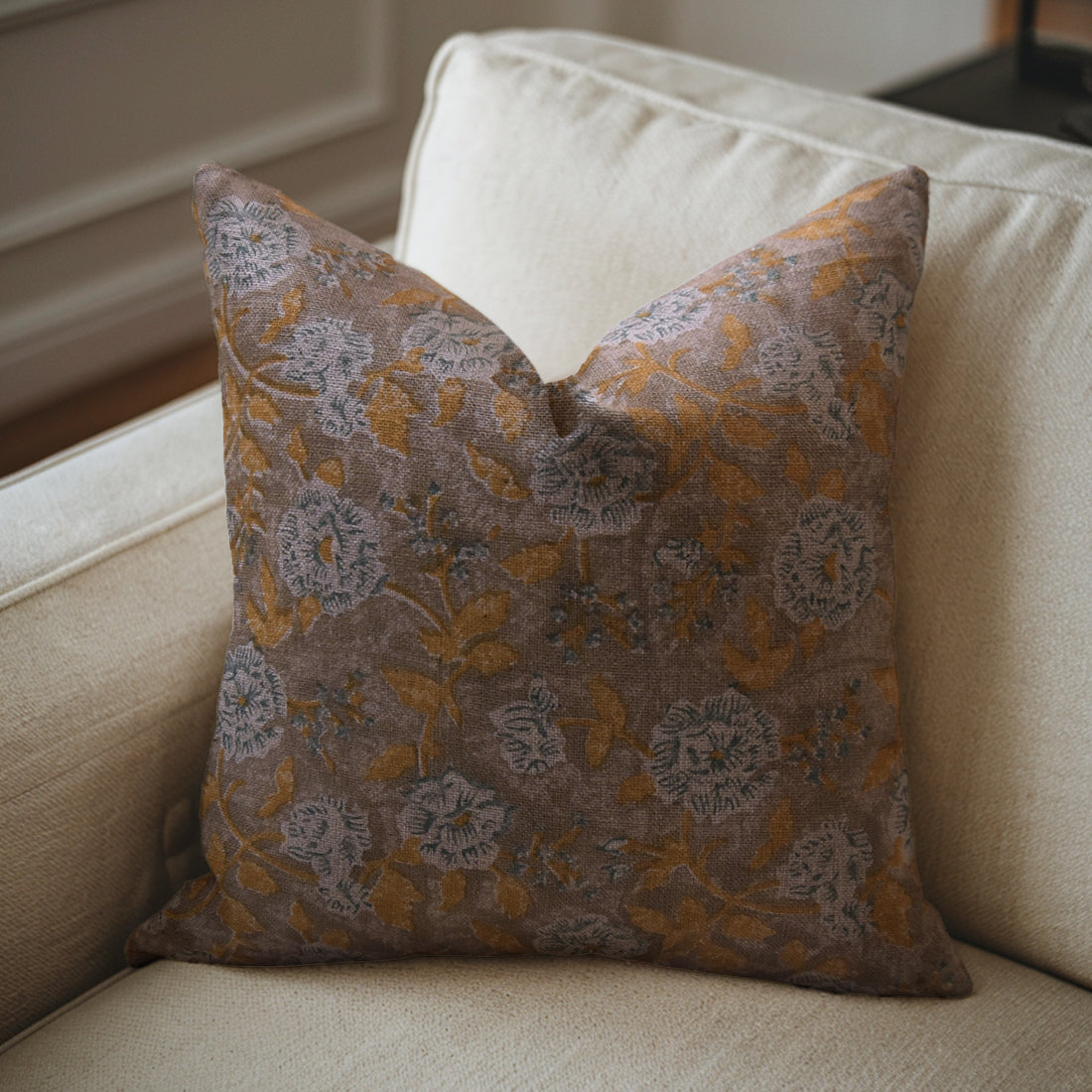 Linen pillow with floral pattern on a beige sofa