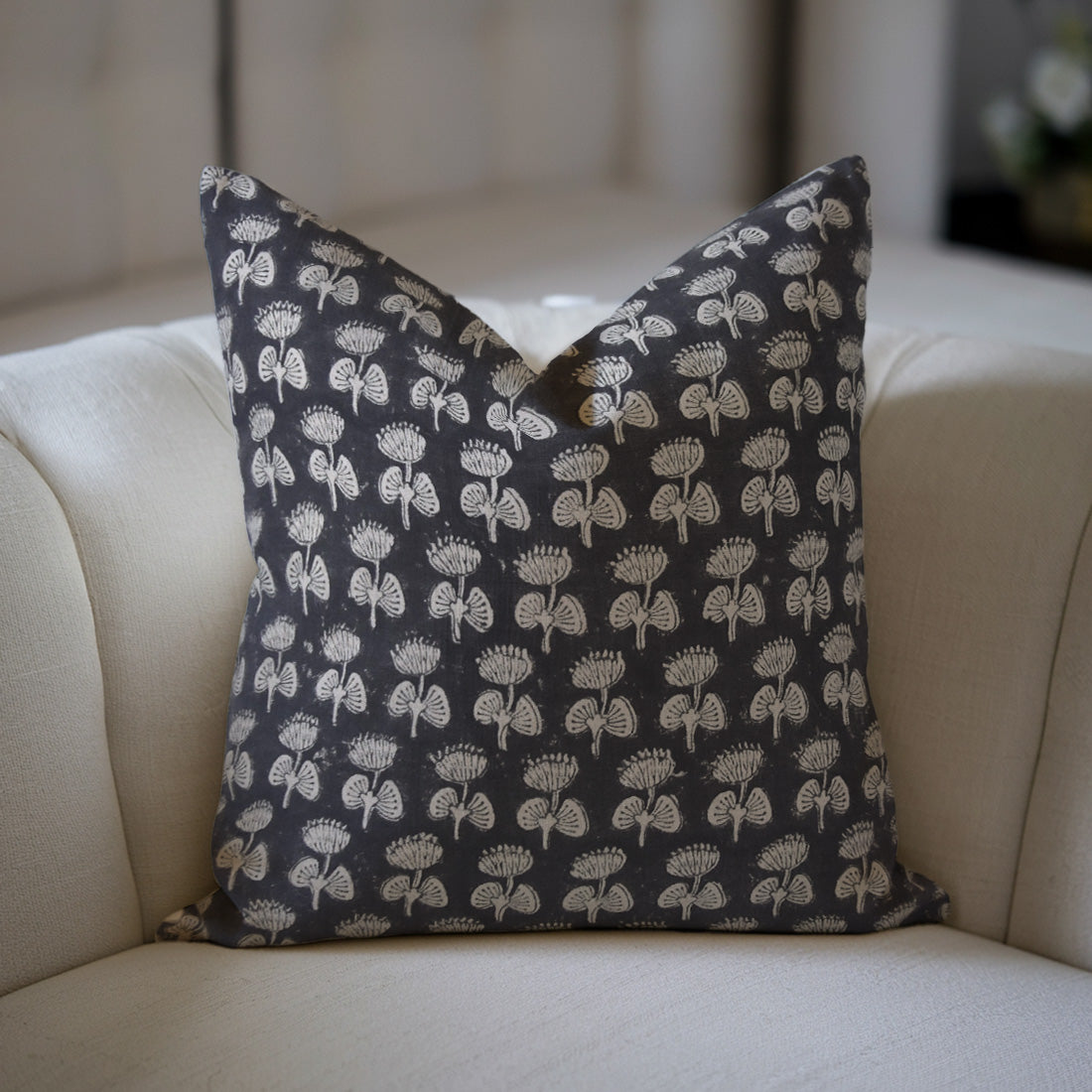 Black Floral pillow with floral pattern on a beige sofa