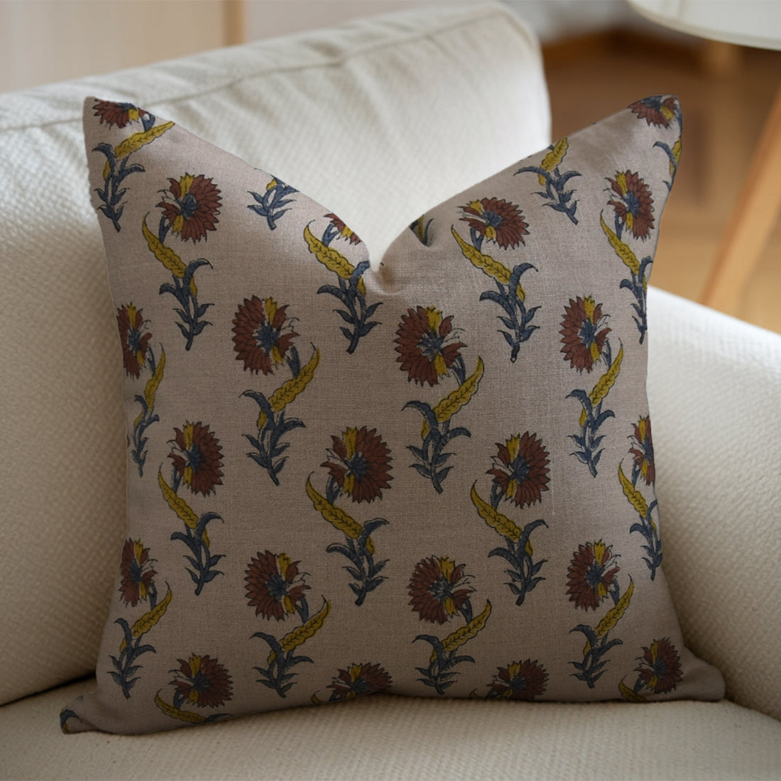 Decorative pillow with a floral pattern on a beige sofa, styled with a decorative pillow cover.