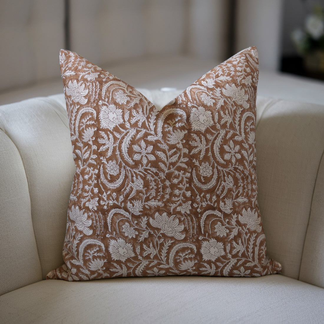 Decorative pillow with floral pattern on a beige sofa