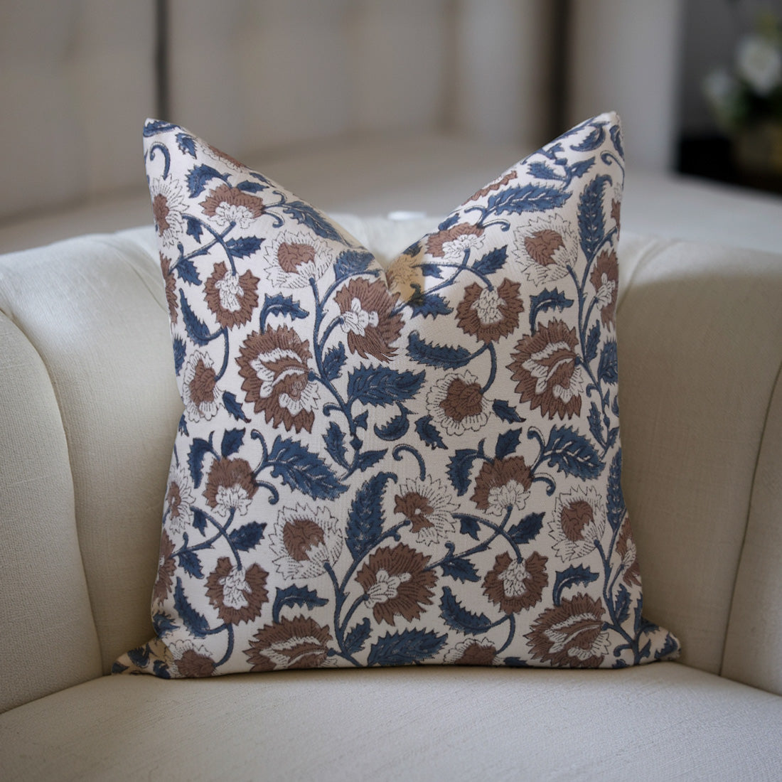 Decorative floral pillow on a beige sofa