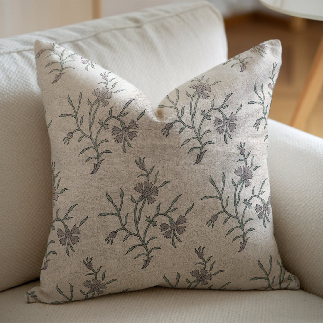 Linen pillow with floral pattern on a beige sofa