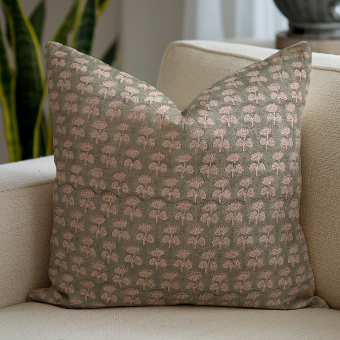 Patterned pillow on a beige sofa with a blurred background