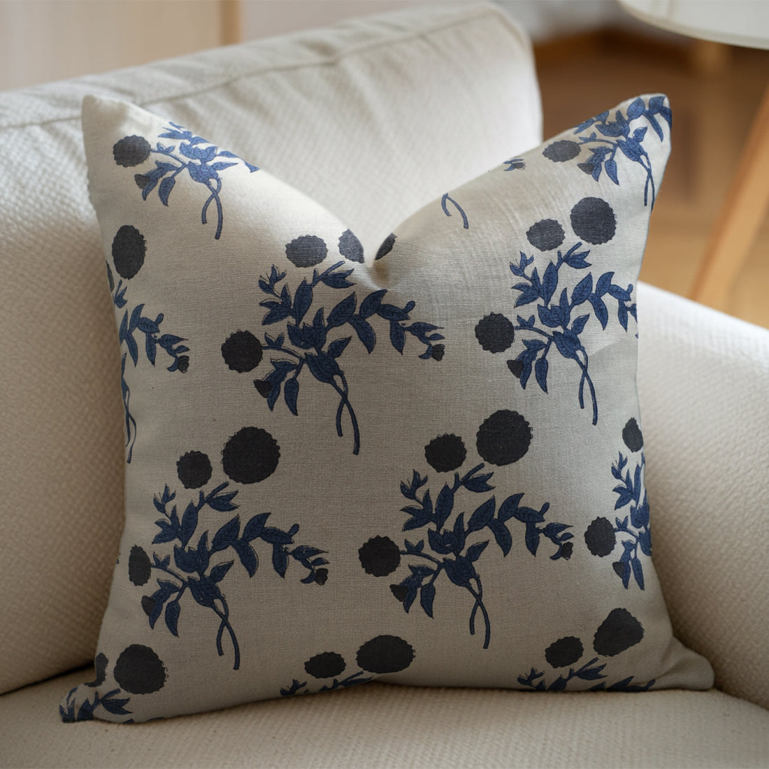Decorative pillow with blue floral pattern on a beige sofa