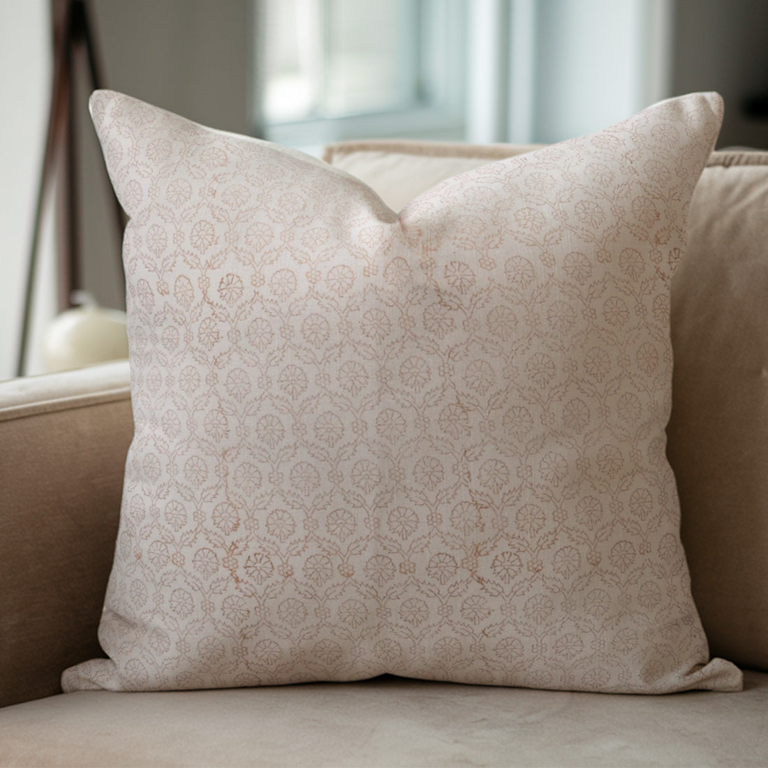 Decorative pillow with a subtle pattern on a beige sofa