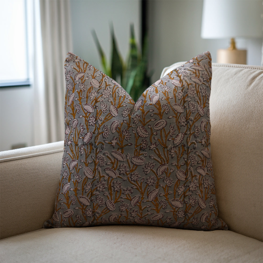 Linen blend pillow with floral pattern on a beige sofa