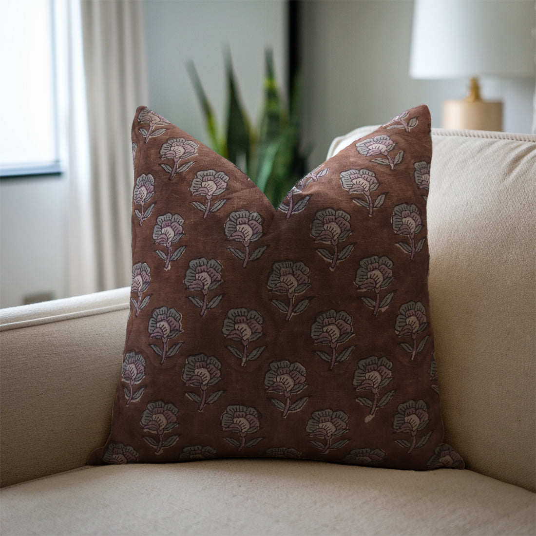 Decorative brown pillow with floral pattern on a beige sofa