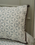 Decorative pillow with geometric pattern on a bed