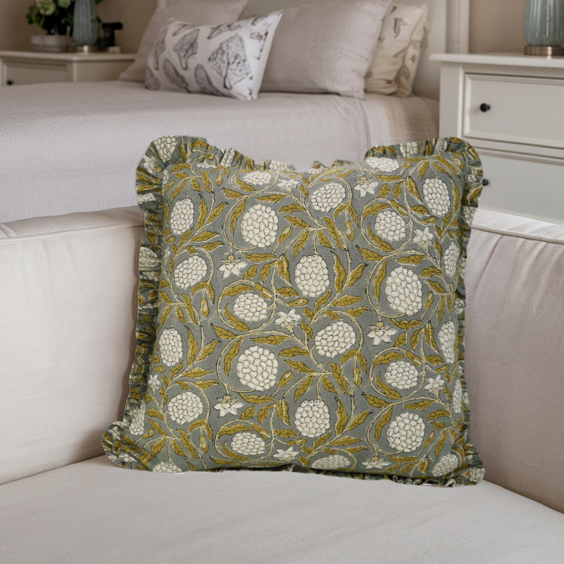 Beige sofa with charming frill linen pillow covers in floral design.