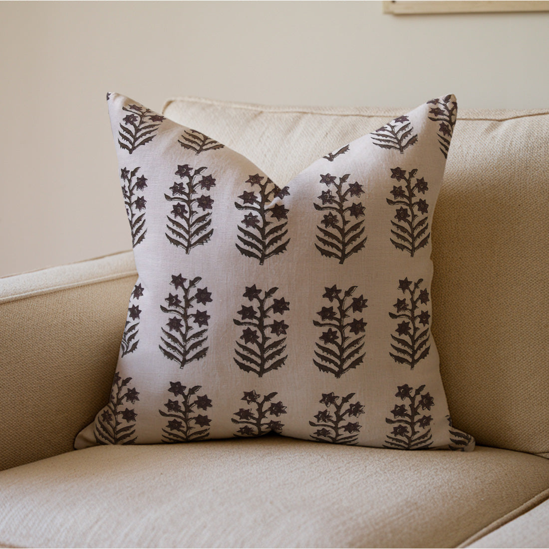 Handcrafted pillow with floral pattern on a beige couch