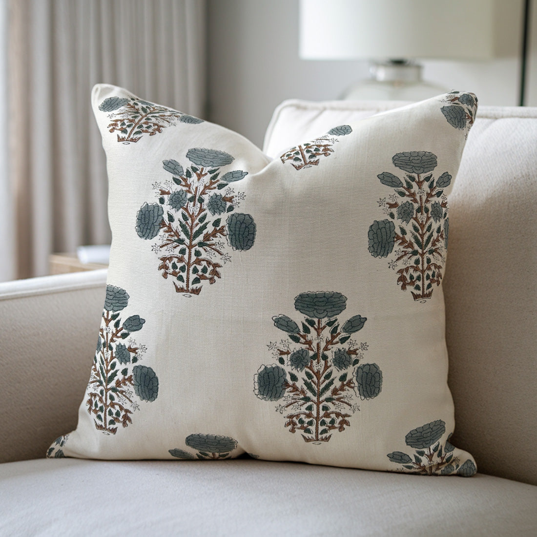 Decorative white pillow with floral pattern on a beige sofa