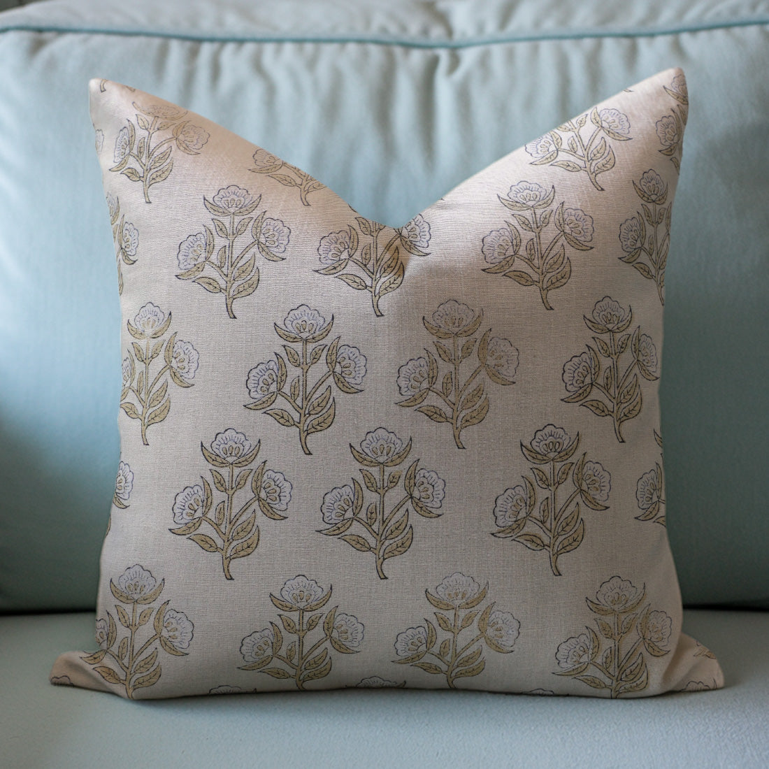Decorative pillow with floral pattern on a light blue sofa