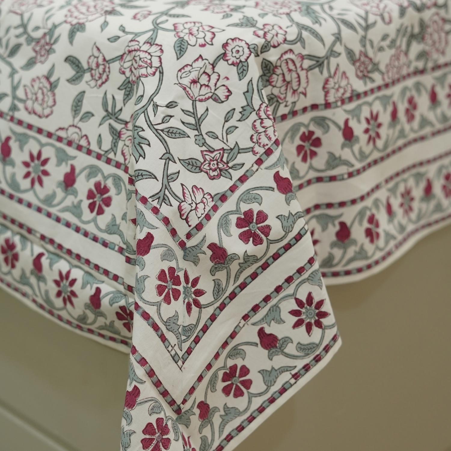 Floral patterned bedsheet with red and green design on a neutral background