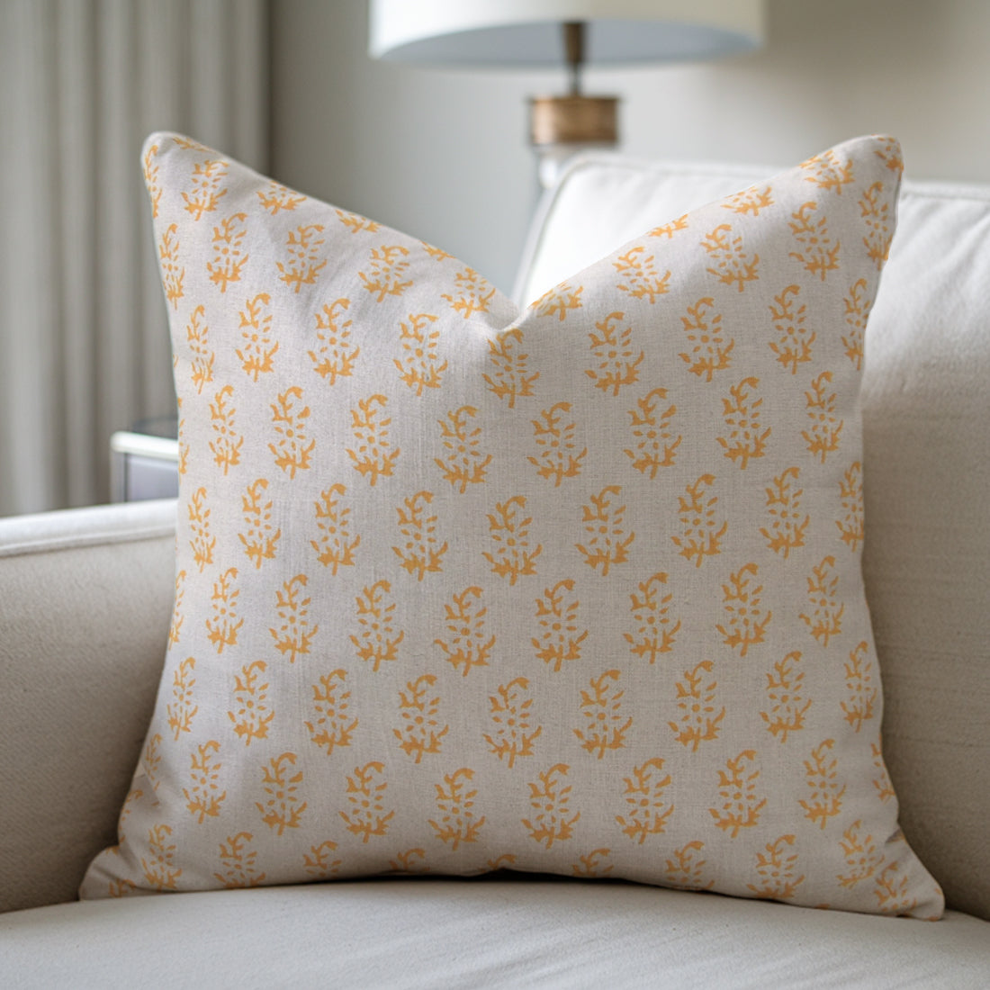 Decorative pillow with yellow floral pattern on a beige couch