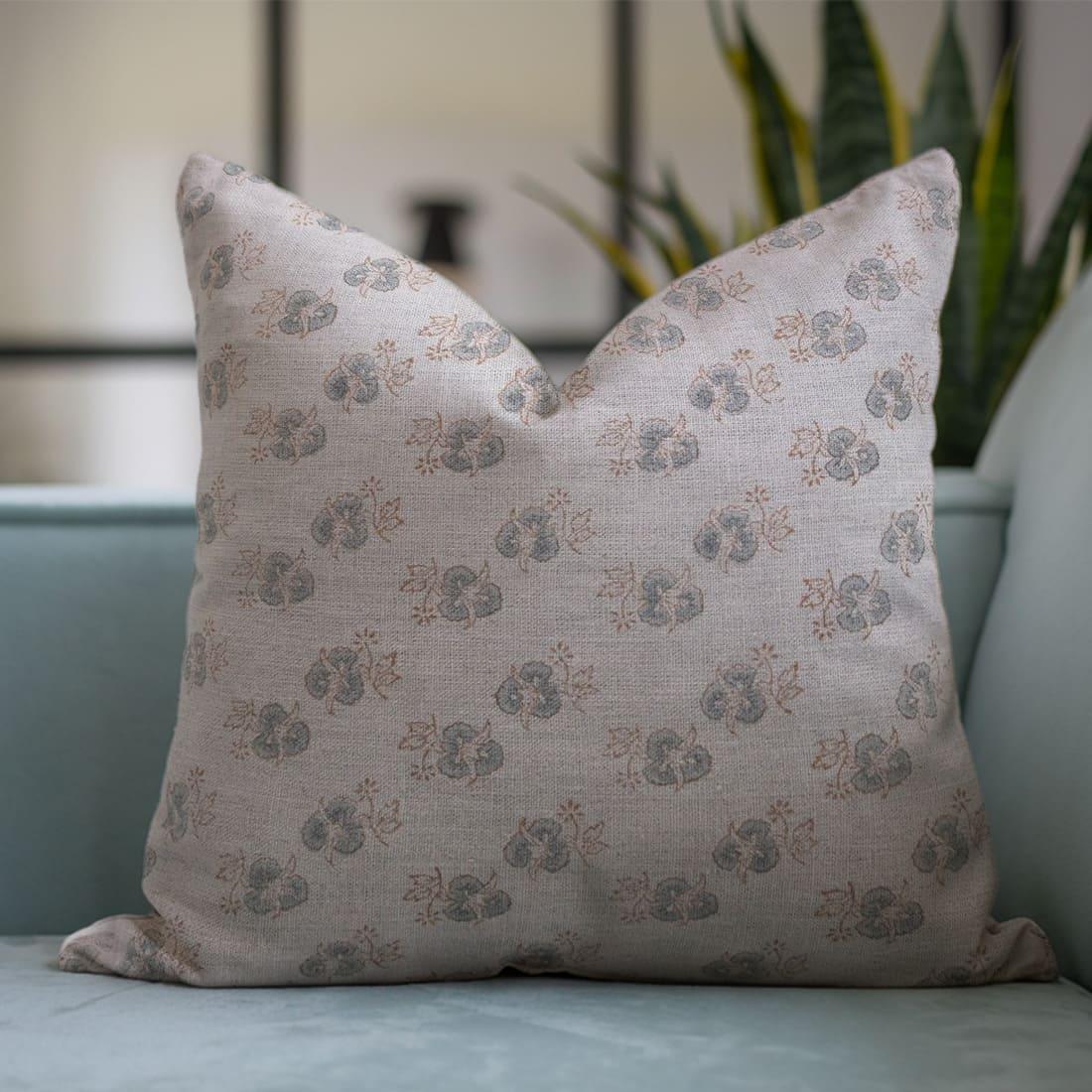 Floral patterned pillow on a light blue sofa 