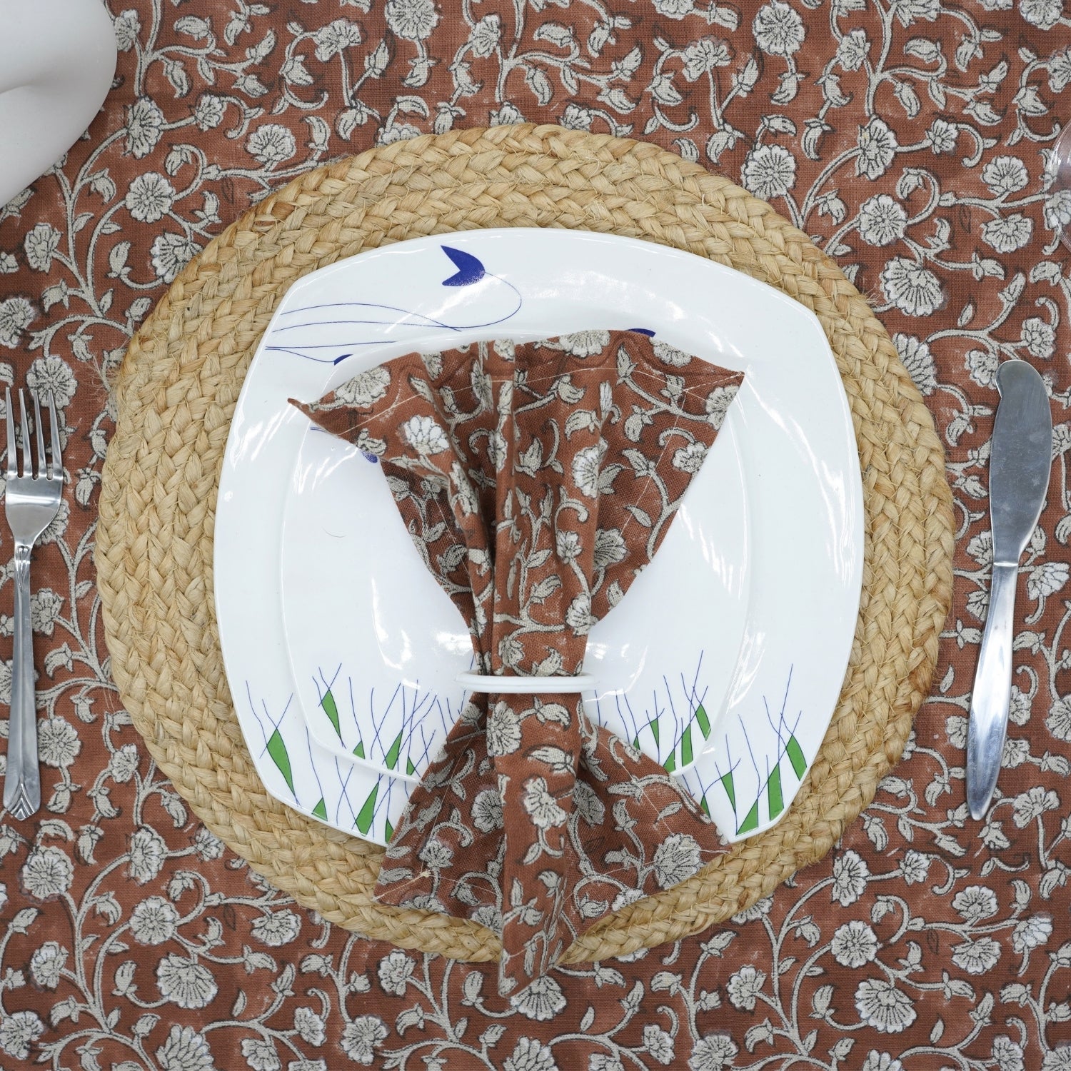 Handcrafted block print brown napkin on a floral plate for a cozy table setting