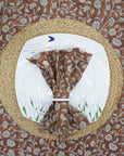 Handcrafted block print brown napkin on a floral plate for a cozy table setting