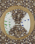 Handcrafted brown napkin set with floral block print on a dining table