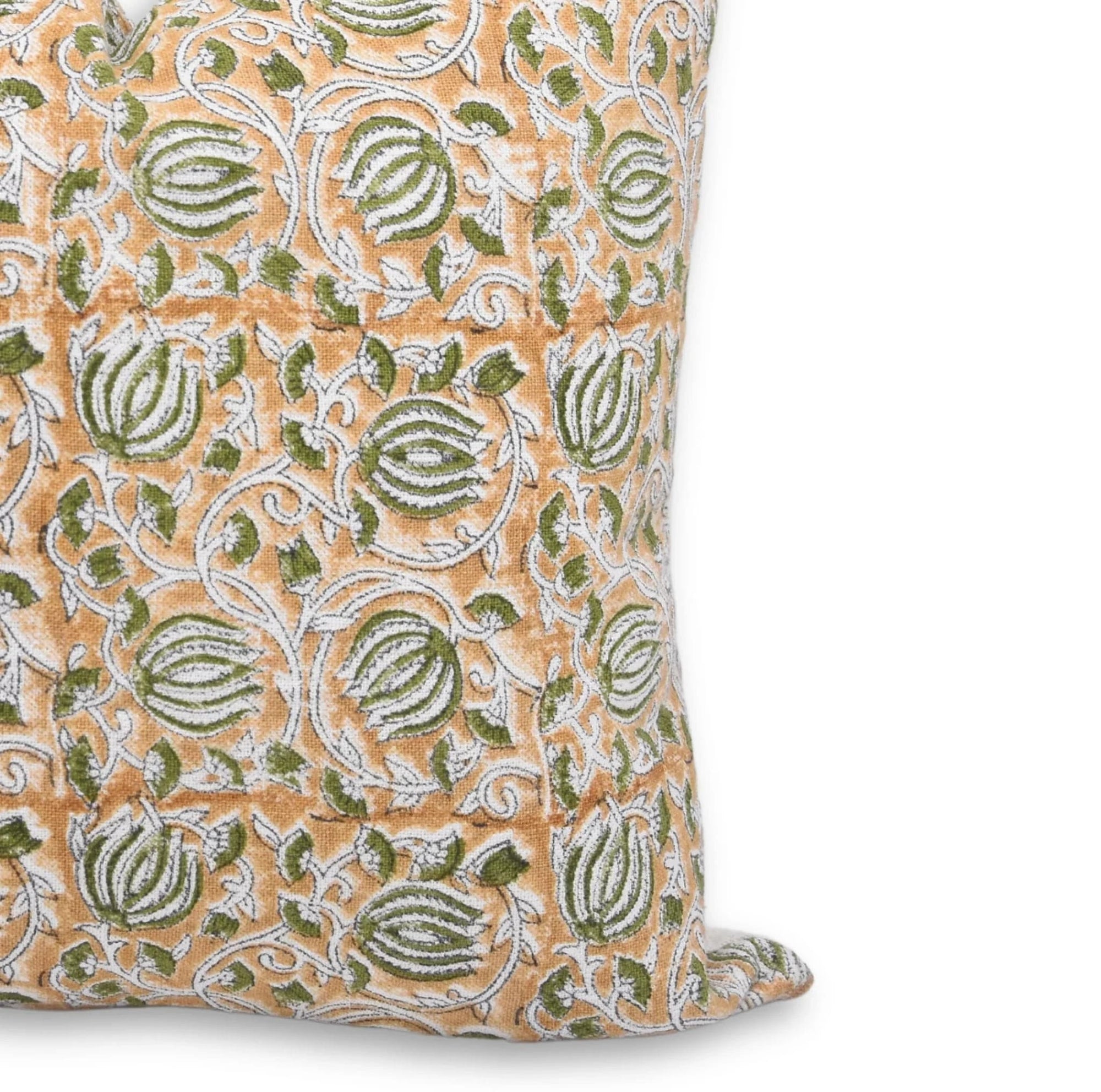 Decorative pillow with intricate green and white pattern on a beige 