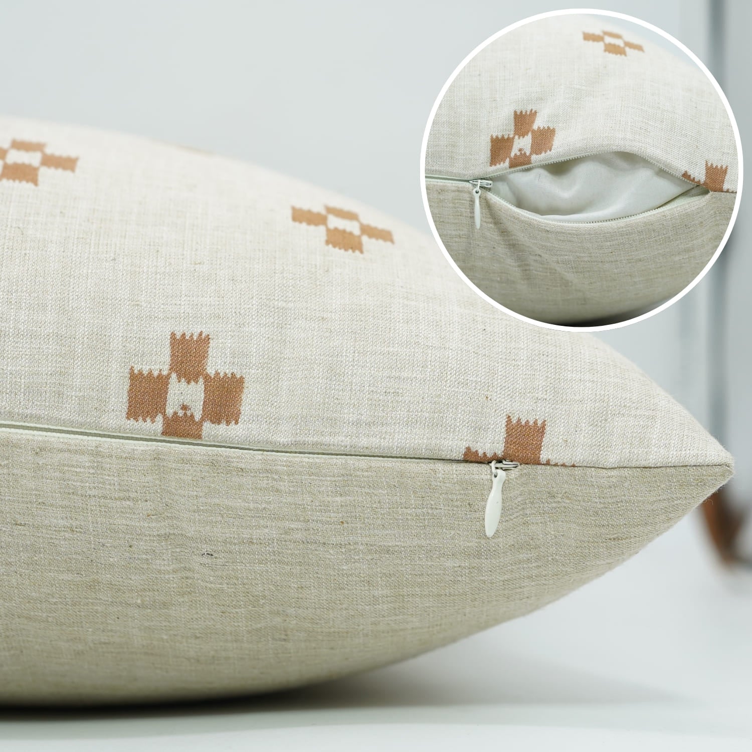 Beige pillow with brown geometric patterns on a light gray background