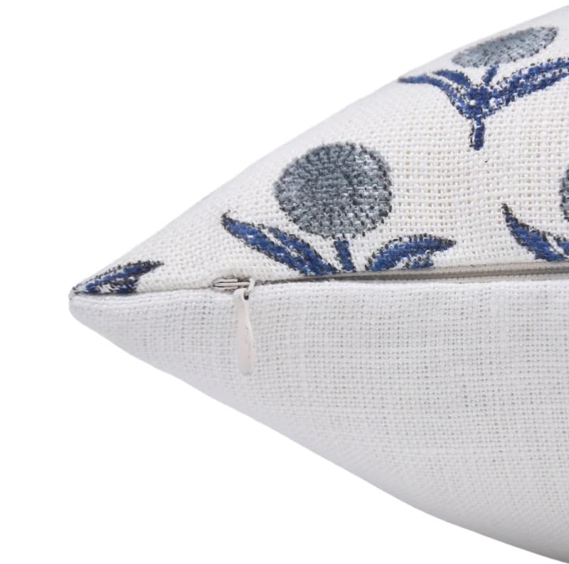 Close-up of a white pillow with blue floral patterns on a off white fabric