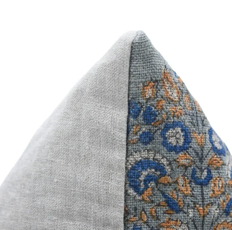 Gray fabric pillow with floral patterned edge on a white background